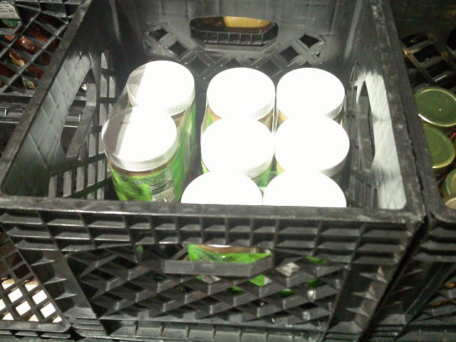 Nine jars in plastic wrap in a crate.